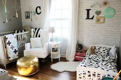 a baby's room with white brick walls and black and white decor on the wall