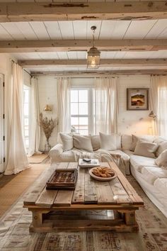 a living room with white couches and wooden tables