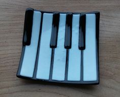 a black and white piano keyboard on a wooden table