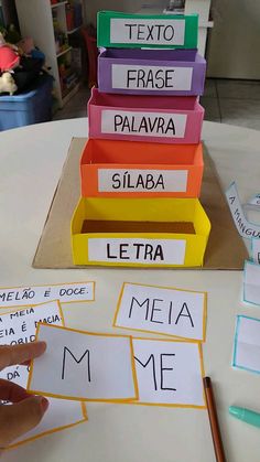 a stack of different colored books sitting on top of a table next to a pencil