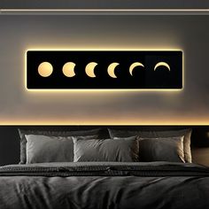 a bed with four phases of the moon lit up on it's headboard