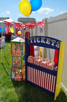 an outdoor carnival booth with clowns and circus tents