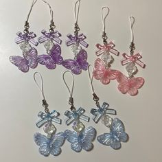 four pairs of earrings with butterfly charms hanging from them