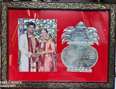 a man and woman standing next to each other in front of a red frame with an ornate border