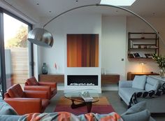 a living room filled with furniture and a fire place in the middle of it's wall