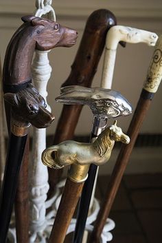 three wooden canes with animals on them and one has a dog head hanging from it