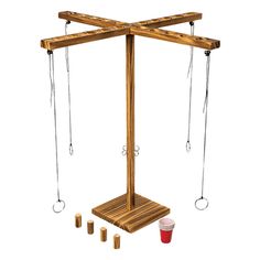 a wooden stand with ropes and cups next to it on a white background in the image