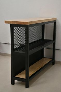 a black shelf with a wooden top and metal mesh design