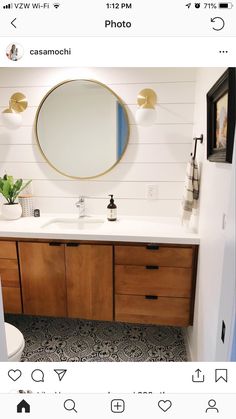 a bathroom with two sinks and a round mirror on the wall above it's counter