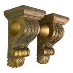 two gold colored corbge brackets on white background