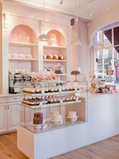 a display case filled with lots of cakes and cupcakes on top of glass shelves