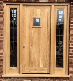 a close up of a wooden door on a brick building with two glass panes