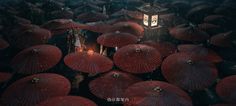 a large group of red umbrellas with a lantern in the middle surrounded by smaller ones