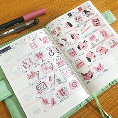 an open notebook with stickers on it next to a pen and paper clipping