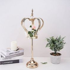 a candle holder with flowers on it next to some books and a potted plant