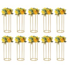 twelve sunflowers are arranged on gold stands with green leaves and yellow flowers in them