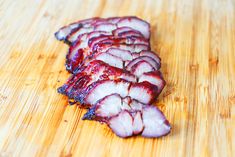 sliced up meat sitting on top of a wooden cutting board