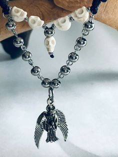 "Dije de la Santa Muerte Plateada con bolas de acero inoxidable platada y craneo blanca terminado en collar con hilo de cordon grueso negro Collar ajustable con cierre minimo desde 16\" pulgadas como collar gargantilla y expandible hasta 28\" pulgadas como collar Material: Santa Muerte plateada con alas Metal rustico 3 cm craneo blanca 6mm bolas de acero inoxidable plateada 6mm, 3mm con cadena de acero inoxidable hilo de cordon grueso color negro Personalizamos el color del cordon, preguntenos!! Silver Stainless Steel Skull Jewelry, Silver Skull Stainless Steel Jewelry, Black Necklace, Pendant Necklaces, Silver Bracelet, Necklace Lengths, Beaded Necklace, Charm Bracelet, Handmade Items