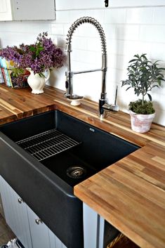 a kitchen sink sitting under a faucet next to a wooden counter top