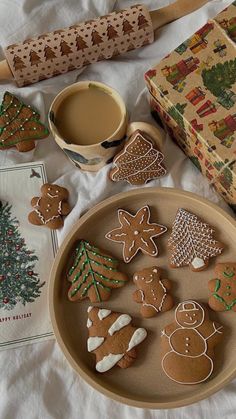 gingerbreads and cookies are arranged on a plate next to a cup of coffee