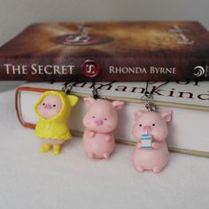 three little pig key chains are sitting on top of a bookshelf next to a book