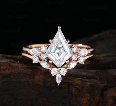 a white diamond ring sitting on top of a piece of wood