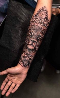 a woman's arm with a lion tattoo on it