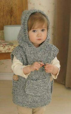 a small child wearing a knitted hooded sweater