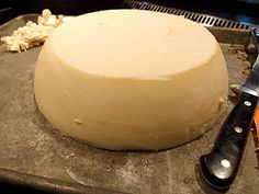 a knife is sitting next to a cheese ball on a pan with other ingredients around it