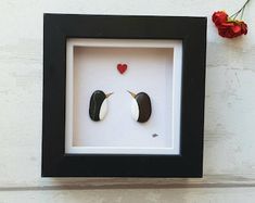 two birds in a shadow box with a red rose