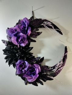 a wreath with purple flowers hanging on the wall