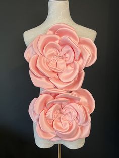 a mannequin with two large pink flowers on it's back and sides