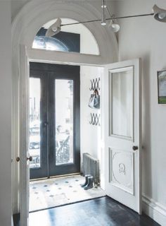 an entry way with a black door and white walls