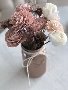 a mason jar filled with flowers on top of a table