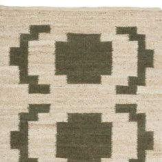 a green and white rug with square shapes on the bottom, in various shades of brown