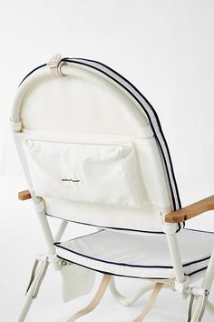 a white baby's rocking chair with blue stripes on the seat and back, in front of a white background