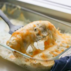 a glass casserole dish filled with cheese and meat covered in gravy