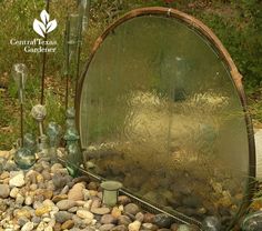 there are many glass bottles and rocks in the ground next to each other on this rock garden