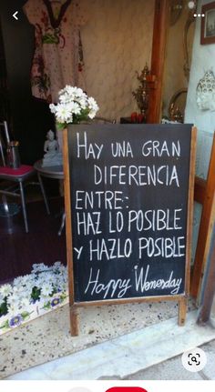 a sign in front of a store that says happy wednesday and has flowers on it