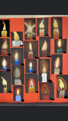 many candles are lit on the wall with pictures in front of them that show different shapes and sizes