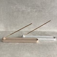 two wooden sticks sticking out of the top of a toothbrush holder on a table