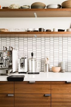 the kitchen counter is covered with dishes and cups