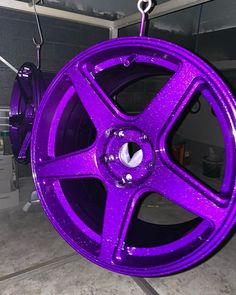 a purple wheel hanging from a hook in a garage