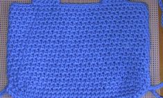 a blue crocheted bag sitting on top of a table