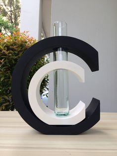 a black and white letter sitting on top of a table next to a glass vase