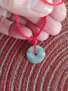 This pendant is made of 100%       Green Jade. Hand carved 20*20       mm Jade Safety Button.  It's a       Original color and high quality.        Hand made Red color Necklace.        with 6 mm Red Jade bead.  Jade safety Button is one of the.        most popular pendant in China .       When you driving or traveling       You need wear the Jade pendant.  Necklace is a adjustable. Green Amulet Round Necklace, Green Round Amulet Necklace, Green Amulet Style Round Necklace, Green Adjustable Round Pendant Jewelry, Green Round Disc Necklace For Gift, Buddha Hand, Jade Buddha, Jade Pendant Necklace, Red Jade