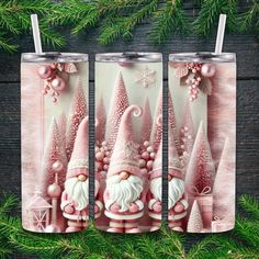 two christmas themed tumblers with santa clause and trees in the background on a wooden surface