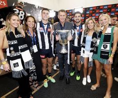 a group of people standing around each other holding a trophy