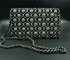 "Stunning black velvet evening bag, hand embroidered zardozi clutch, with shimmery silver and green metallic flowers in a geometric pattern and embellished with genuine green onyx stones, to give an opulent, sophisticated 3D effect. The bag shimmers and shines with the most alluring look. Perfect for an Irish friend, or to go out on St. Patrick's Day. Add an eye-catching pop of color, texture and sparkly bling to your overall party look. It is just the right size to hold your essentials for the Traditional Silver Bag For Reception, Traditional Silver Bags For Reception, Black Evening Bag With Handwork As Gift, Formal Rectangular Evening Bag With Dori Work, Rectangular Evening Bag With Dori Work, Traditional Black Clutch With Handwork, Traditional Black Evening Bag With Handwork, Traditional Black Evening Bag For Festive Occasions, Festive Black Rectangular Evening Bag