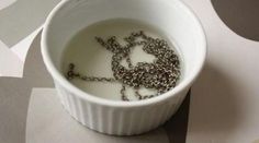 a white bowl filled with liquid sitting on top of a table next to some circles